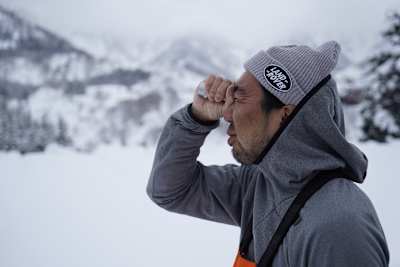 滑る予定の斜面を単眼鏡で覗き込む永井