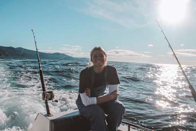 Lizzie Stokely smiles in camera while fishing on a boat