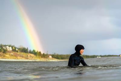 Surfer awaits perfect wave outside of Lawrencetown, Nova Scotia. 
