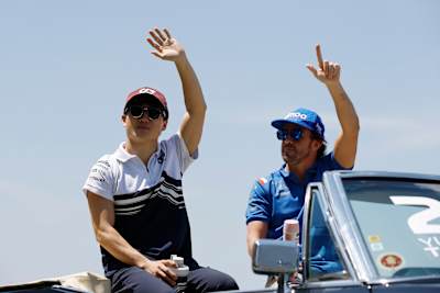 Yuki Tsunoda and Fernando Alonso (right) wave during the drivers' parade
