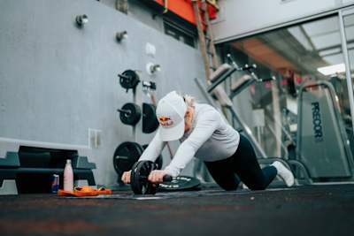 La championne de ski freestyle Tess Ledeux fait du gainage avec une roue abdominale pendant une séance d'entraînement fitness.