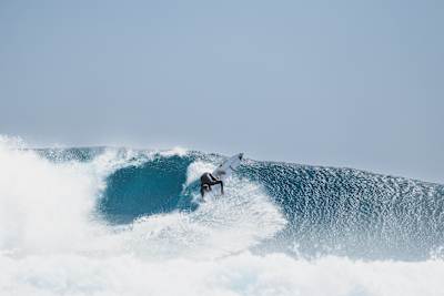 On August 18, 2025, Red Bull athlete Jordy Smith rides a massive wave at the legendary Cloudbreak surf spot in Fiji, showcasing his dynamic style and fearless energy