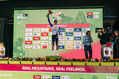 Pellizzari feiert auf dem Podium den Etappensieg.