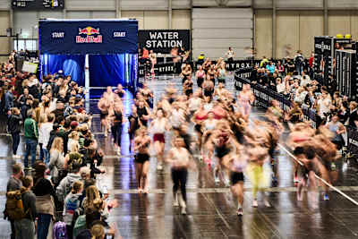 At the HYROX race in Vienna in February 2026, athletes dash from the iconic Red Bull arch, cheered on by the crowd.