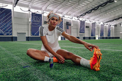 Trinity Rodman stretching her hamstring