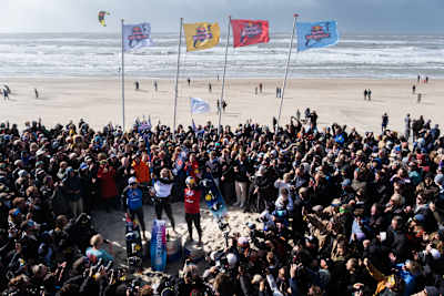 Op 15 september 2025 staat het Mens Podium triomfantelijk bij de Red Bull Megaloop in Noordwijk, Nederland, omringd door een energieke menigte en zwaaiende Red Bull Megaloop vlaggen