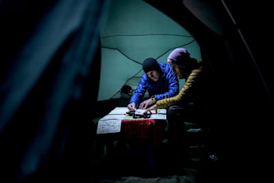 Ryan Sandes and Ryno Griesel study maps and navigation equipment inside a tent during their Mount Kenya Expedition in Kenya on 29 July 2026