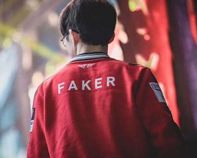 Faker, joueur professionnel de League of Legends au sein de T1, arrive sur scène, vêtu de sa veste rouge floquée à son nom.