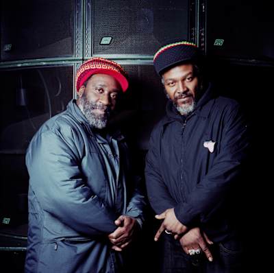 Mikey Dread and Ras Kayleb pose with a soundsystem