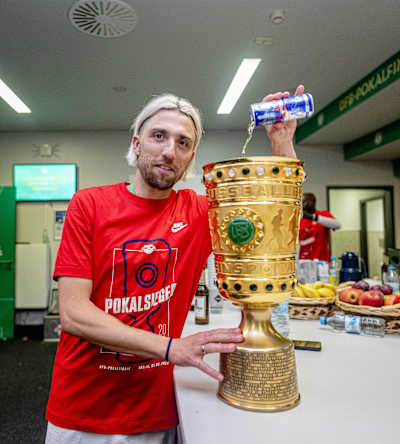 Kevin Kamp schüttet eine Dose Red Bull in den DFB-Pokal.