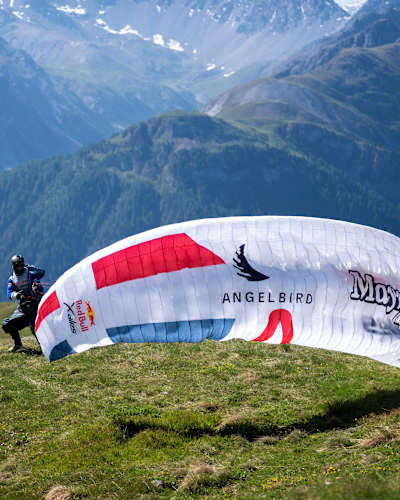 In 2025, Benedikt Dornauer launches his paraglider during Red Bull X-Alps in Guarda, Switzerland, with stunning alpine vistas setting the backdrop for this extreme adventure challenge