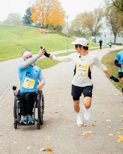 Florian Neuschwander teilt ein High Five mit einem Rollstuhlfahrer beim Red Bull 1 Pro vs. 80 Amateure in München, Deutschland, am 31. Oktober 2025, um Energie und Inklusion zu feiern