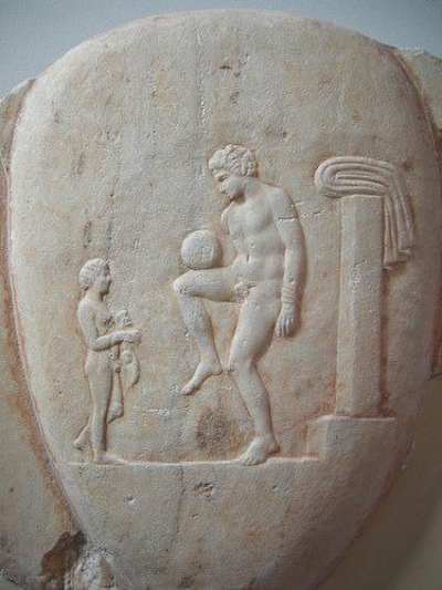 Bas-relief sur vase représentant un jeune grec s'entraînant avec un ballon. 