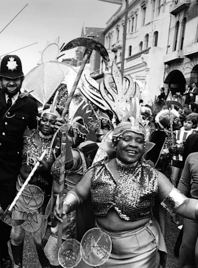 A policeman and carnival-goers enjoying Notting Hill Carnival.