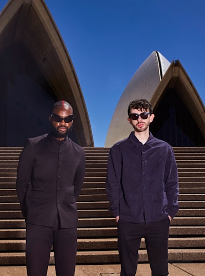 Genesis Owusu and Alex Turley pose for a portrait in front of the Sydney Opera in Sydney, Australia on December 13, 2022.  