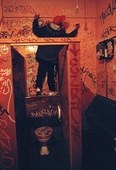 Boy tagging the wall of a toilet in Brick Lane, London, 2005