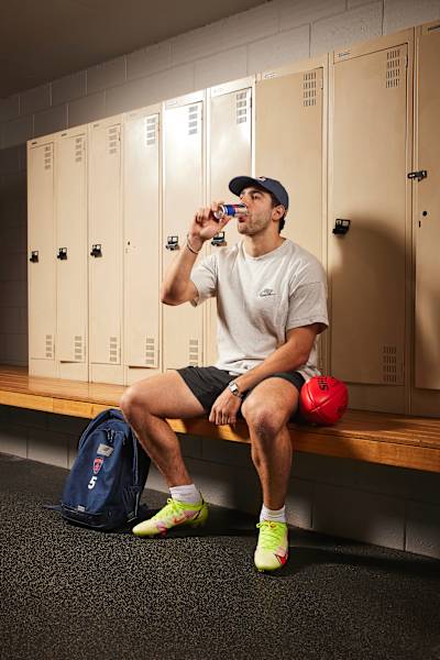 Christian Petracca in the locker room drinking Red Bull