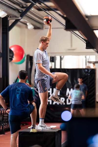 Australijski krykiecista Cameron Green wykonuje ćwiczenia na równowagę podczas sesji fitness.