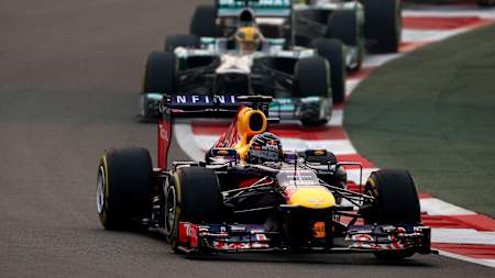 An image of F1 driver Sebastian Vettel in action in a Red Bull car on track during a race.