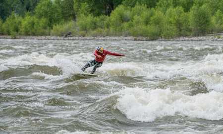 Kai Lenny busts a carve on a river rapid.