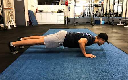 An athlete does a push-up in the gym.