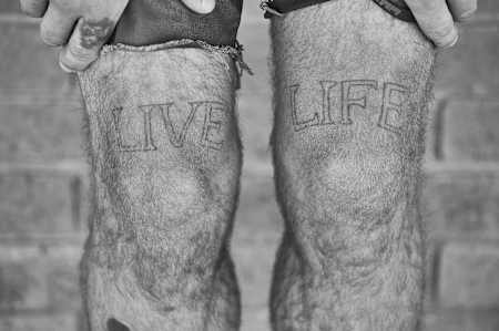 BMX Rider Kriss Kyle zeigt sein Life Live Tattoo auf seinen Beinen zu Hause im Unit 23 Skatepark in Dumbarton, Schottland