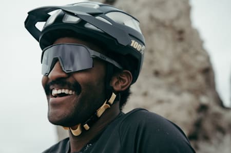 Ein strahlender Biker mit schwarzem Helm von 100%