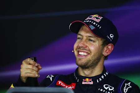 An image of F1 driver Sebastian Vettel in Red Bull cap, smiling.