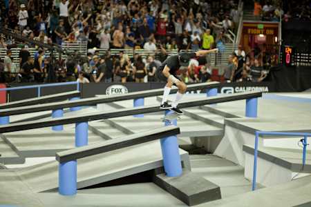 Nyjah Huston pose une Kickflip Backside Tailslide en skateboard à Los Angeles.