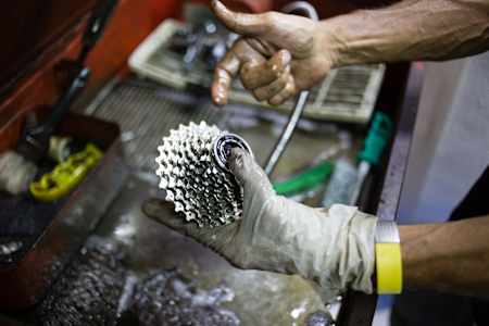 A bike cassette is washed and checked for wear and tear
