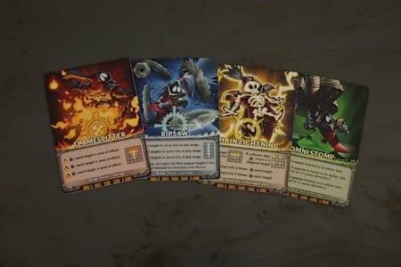 Four cards from Mechs vs Minions, the League of Legends board game. Flamespitter, Ripsaw, Chain Lightning, Omni Stomp
