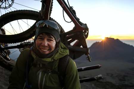 Rebecca Rusch carries her bike up Kilimanjaro