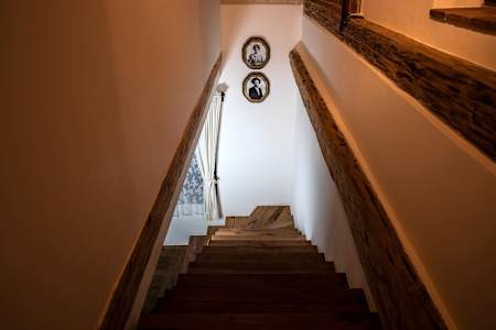 Schody lemované původními trámy. Vedou dolů i nahoru.
