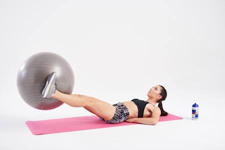 将双手撑于地面，双脚摆放至球上