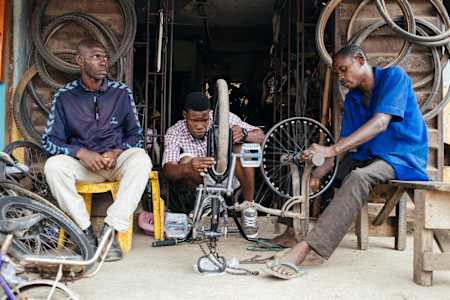 A BMX rider checks the wheel of their bike for wobbles and truing problems.
