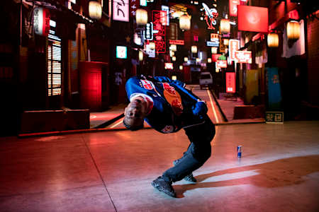 Stalamuerte dancing in front of a city projection.