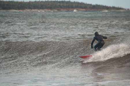 Local surfer rides wave outside of Lawrencetown, Nova Scotia. 