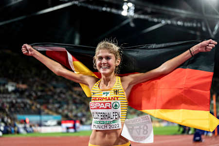 Konstanze Klosterhalfen celebrates her victory at the Women’s 5000m Final during the European Championships 2022, held in Munich, showcasing the German flag at the Olympiastadion