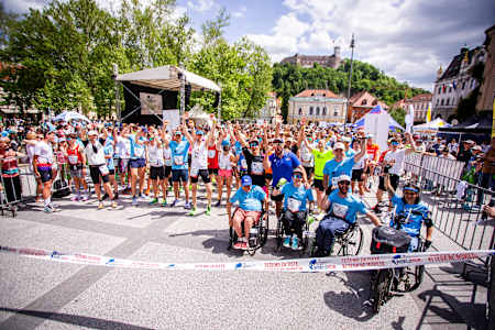 Udeleženci teka Wings for Life World Run 2025 v Ljubljani v Sloveniji se zberejo na startni črti in z navdušenjem podprejo raziskave poškodb hrbtenjače