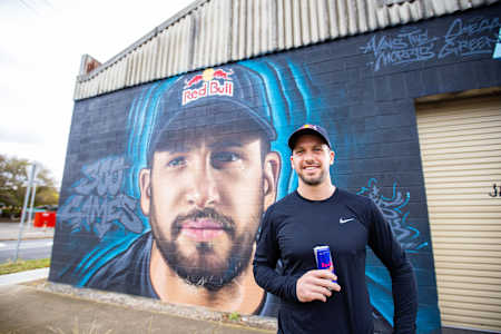 Travis Boak poses at mural in Adelaide