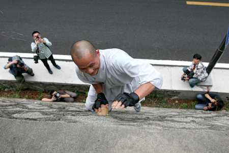 Il monaco Shi Liliang si arrampica su un muro