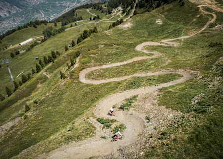 Des pilotes roulent en VTT sur la piste Chôtatai sur le bike park de Verbier.