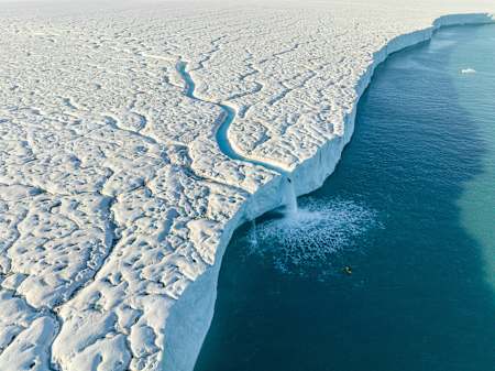 Aniol Serrasolses paddles the river on the Austfonna ice cap in Svalbard