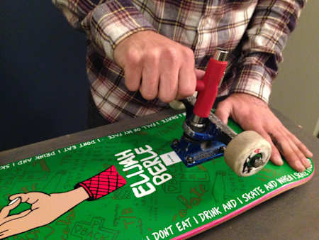 A photo of a person working on a skateboard.