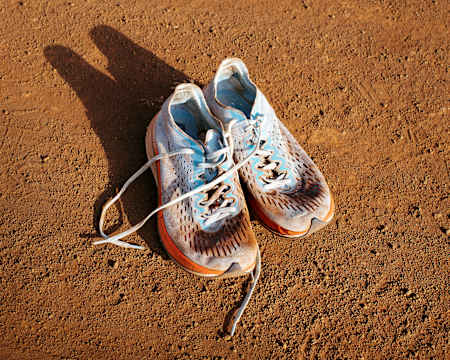 Juliens Laufschuhe: rot vom Sand der Bahn