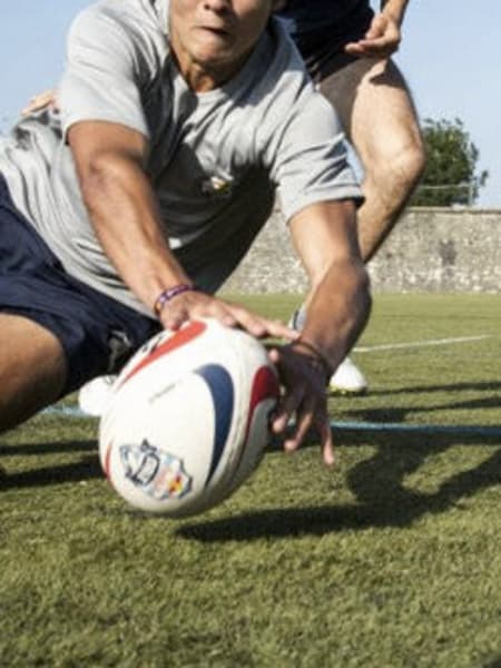 Un joueur attrape le ballon lors d'un match de rugby.