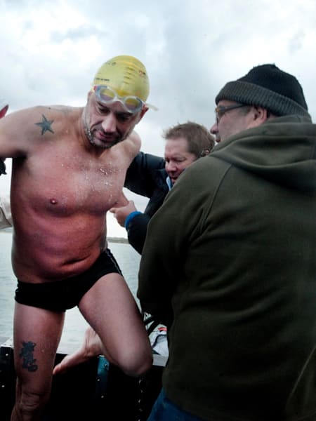 Howard James is helped aboard after finishing