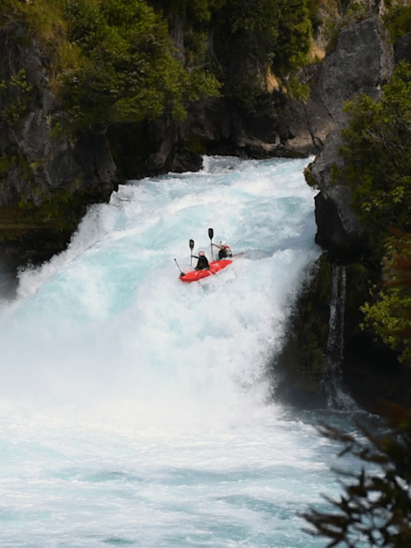 Nouria Newman and Mike Roy kayaking down New Zealand's Huka Falls in a tandem kayak