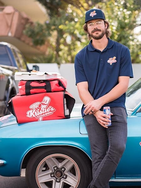 Kris Bryant poses by pizza delivery car.