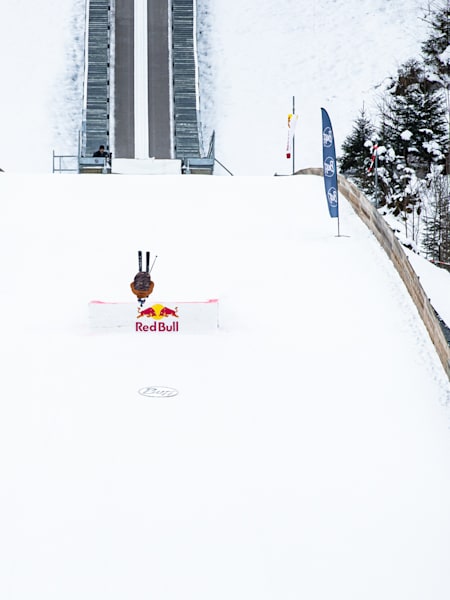 Freeskier Fabian Bösch Mid-Air bei seinem Double Frontflip von der Skisprungschanze in Engelberg.